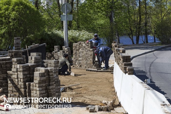 Рабочие перекладывают "пляшущую" плитку на мосту через р. Малая Сестра Рабочие перекладывают "пляшущую" плитку на мосту через р. Малая Сестра